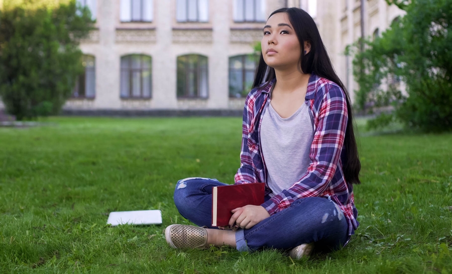 Asian female sitting alone outside