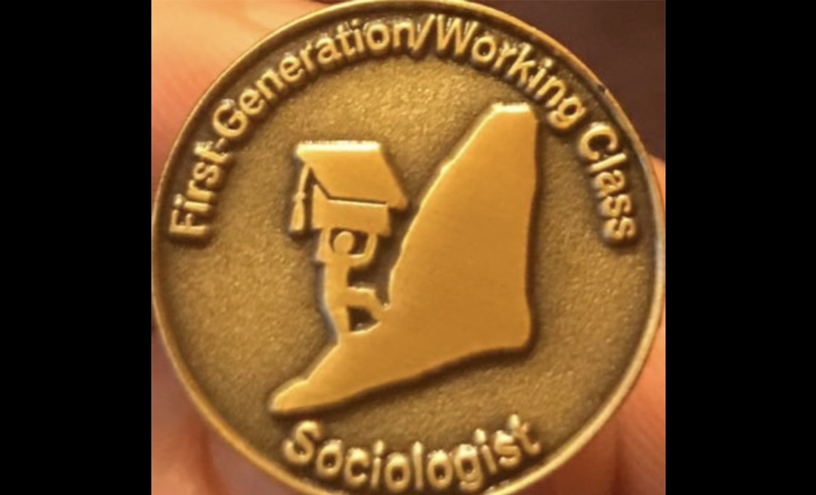 Metal pin featuring person climbing mountain with text reading 