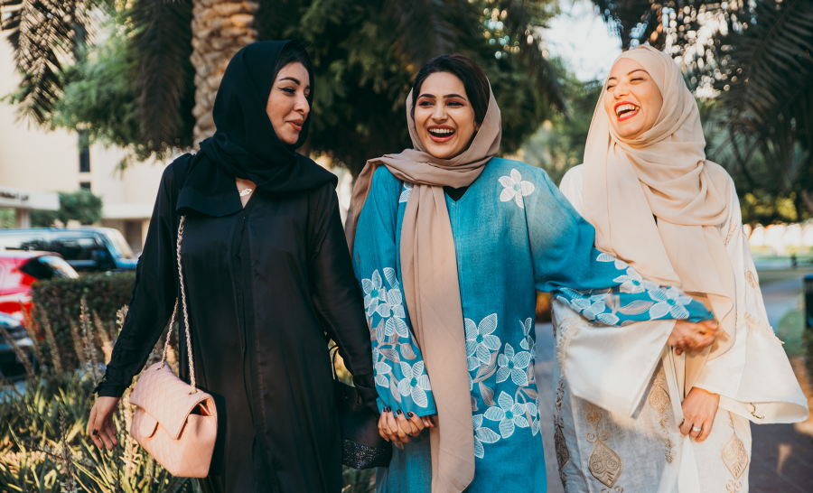 Three female Emirati students walking outside