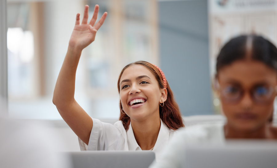 Female Latin student raising hand in class