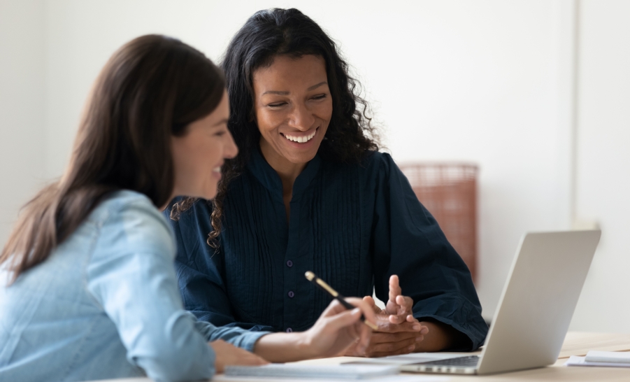 Female mentor with female student at laptop
