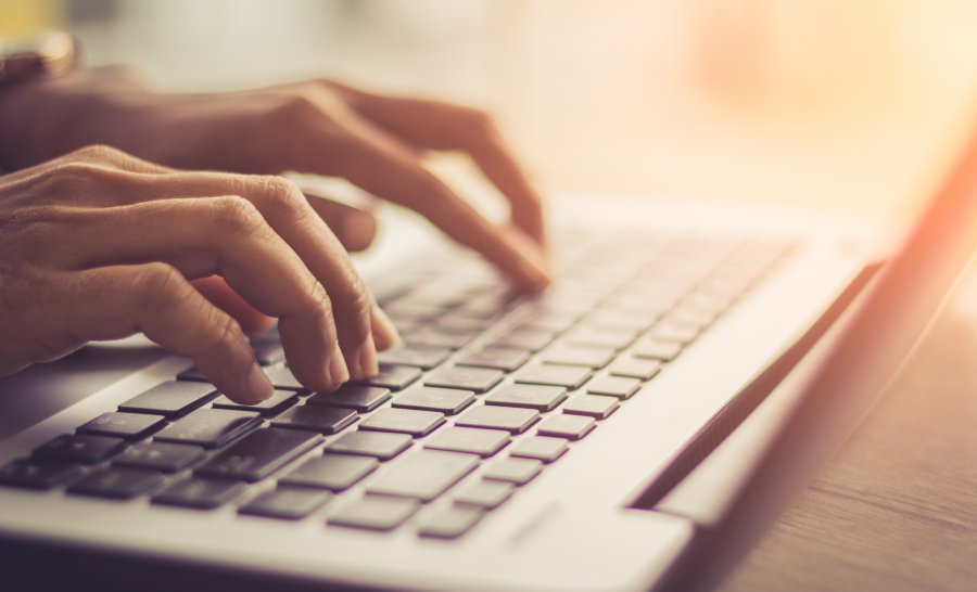 Hands typing on laptop computer