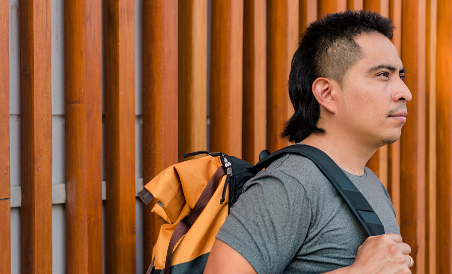 Male Indigenous Student Standing Outside with Backpack