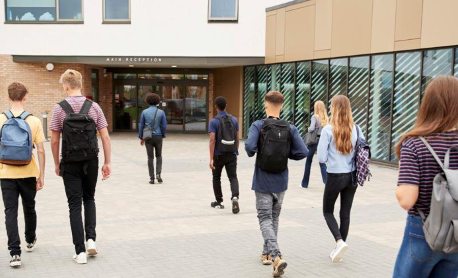 Students walking into and out of campus building between classes