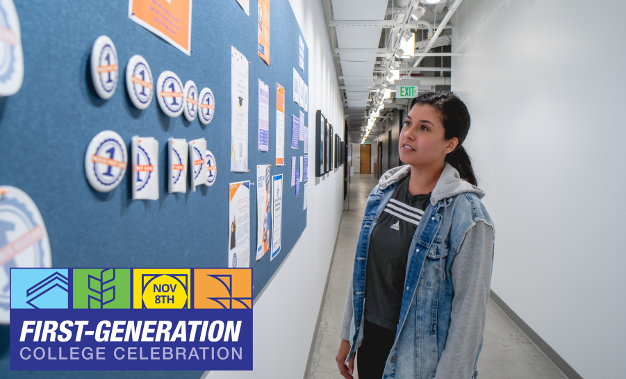 Student staring at bulletin board with first-gen stickers pinned to it in long hallway