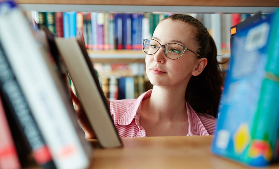 female with glasses in library