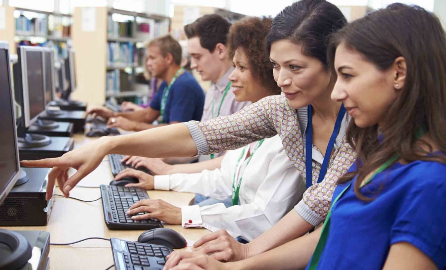 female mentor helps female student in blue shirt