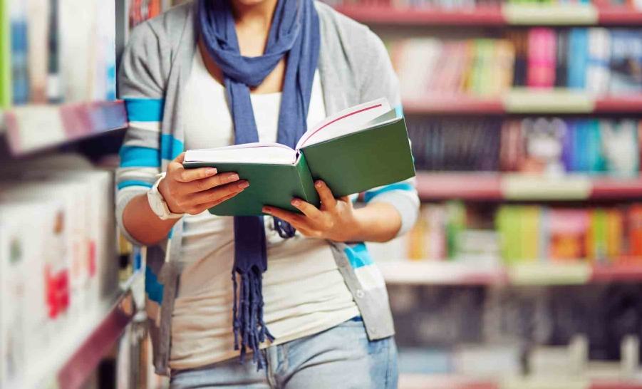 hands holding book in library