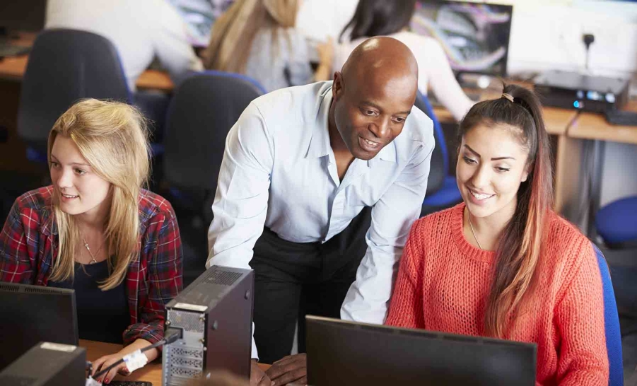male mentor helps female student wearing orange sweater