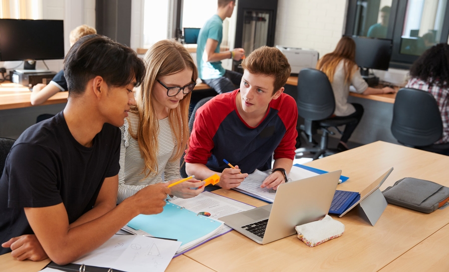 three students chatting in computer lab