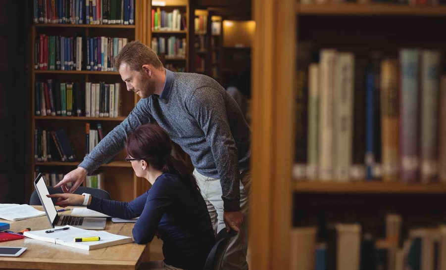 two people researching in library
